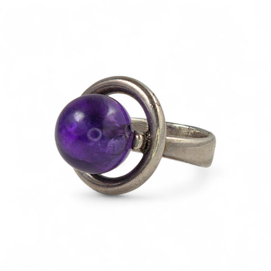 Silver ring with a purple sphere on a white background