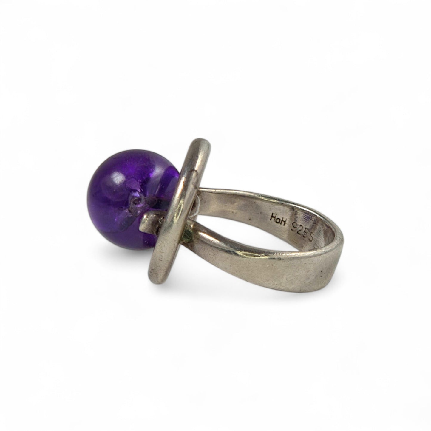 Silver ring with a purple gemstone on a white background