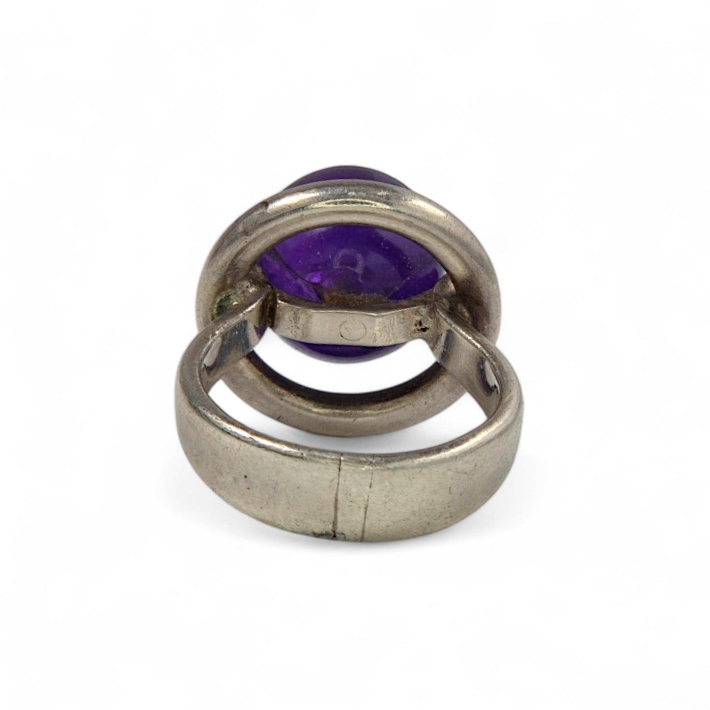 Silver ring with a purple gemstone on a white background