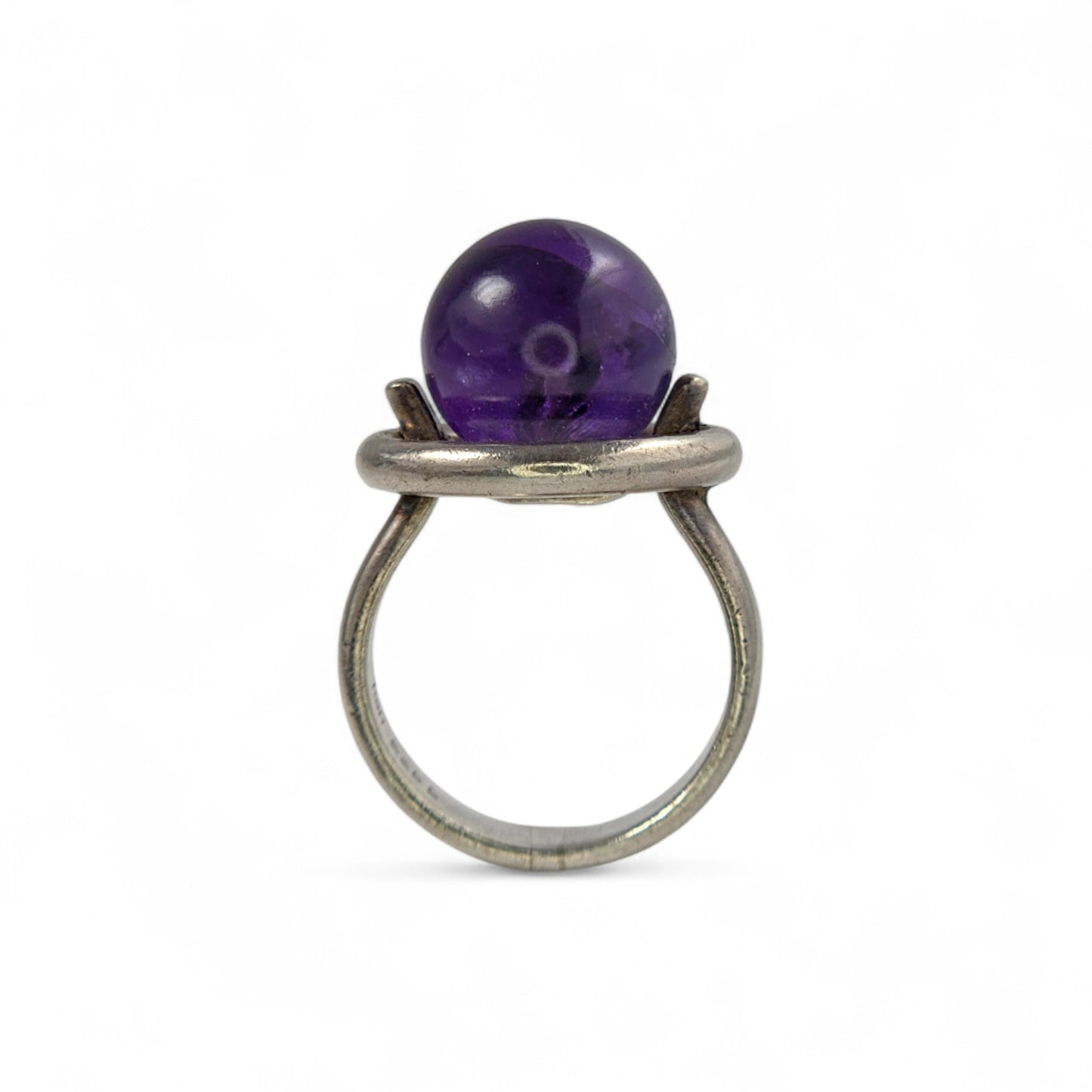 Silver ring with a purple gemstone on a white background