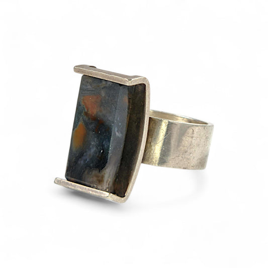 Silver ring with a rectangular stone on a white background