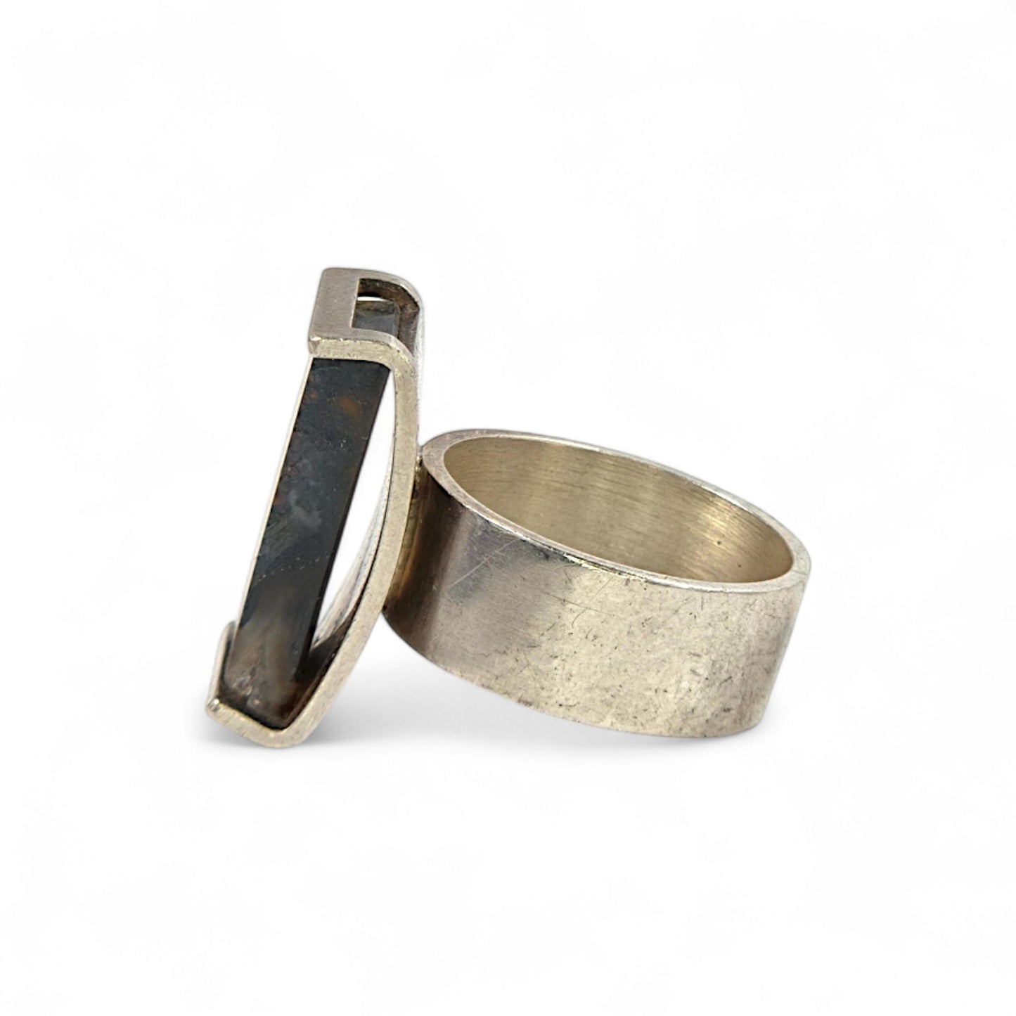 Silver ring with dark stone on a white background