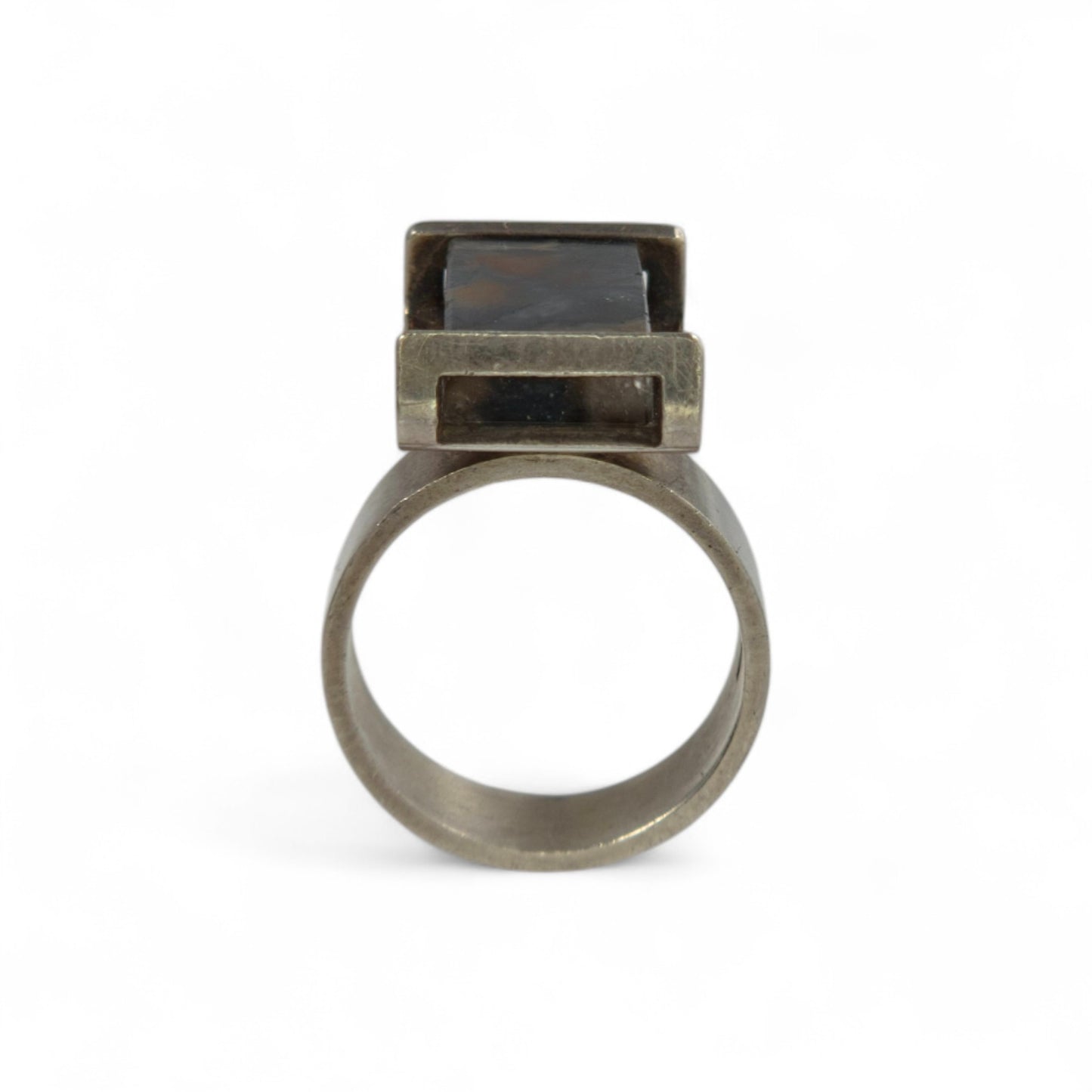Silver ring with a dark stone on a white background