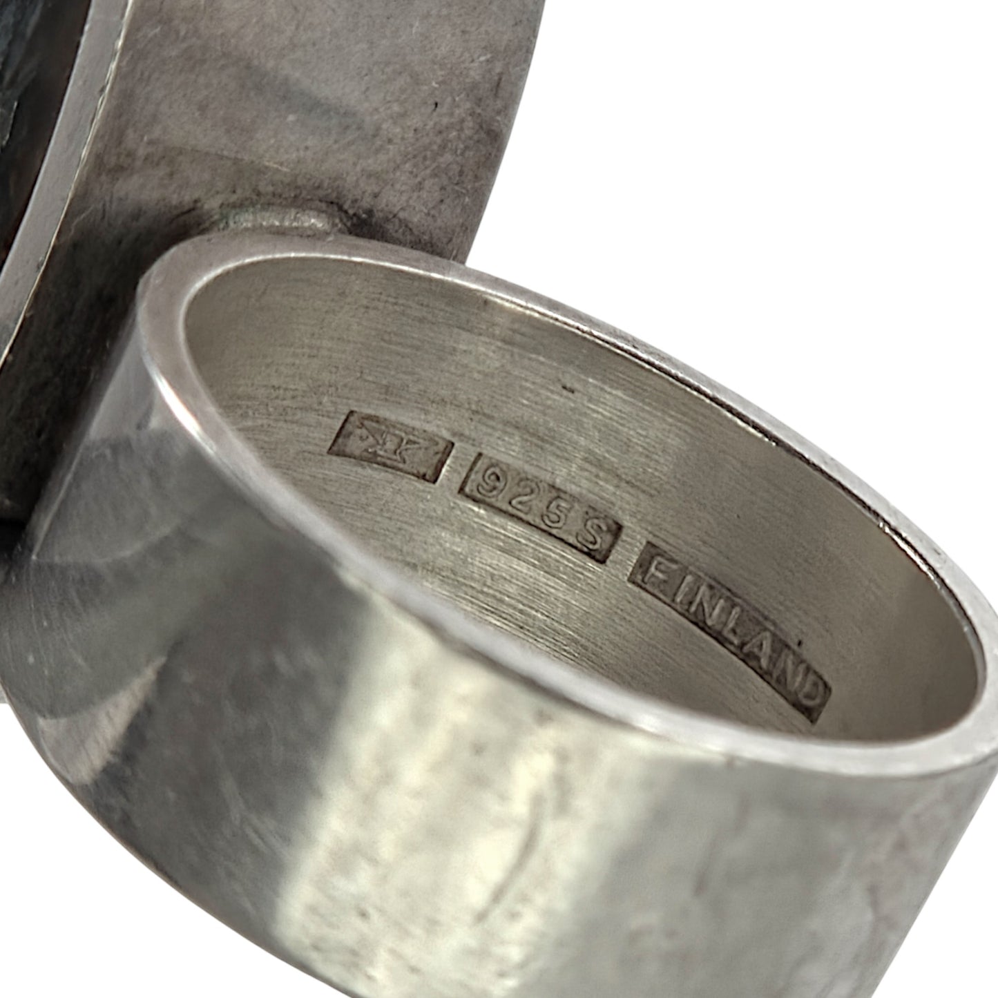 Close-up of a silver ring with 'Finland' inscription on a white background