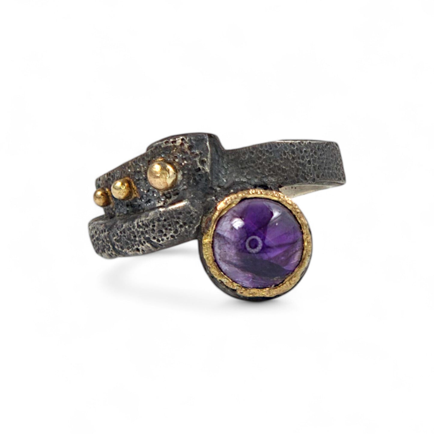 Unique ring featuring a purple gemstone on a white background
