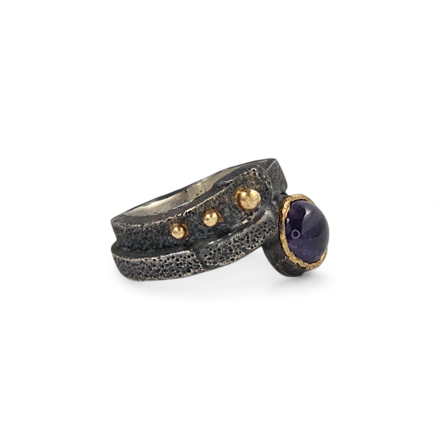Ring with textured band and gemstone on a white background