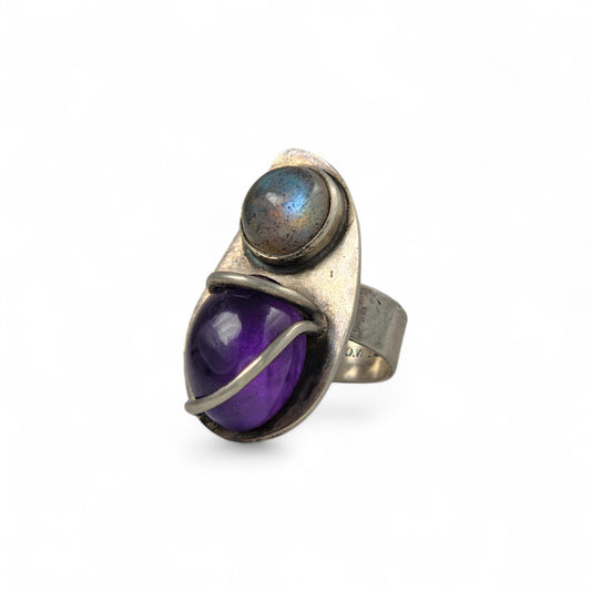Silver ring with purple gemstone and labradorite on a white background