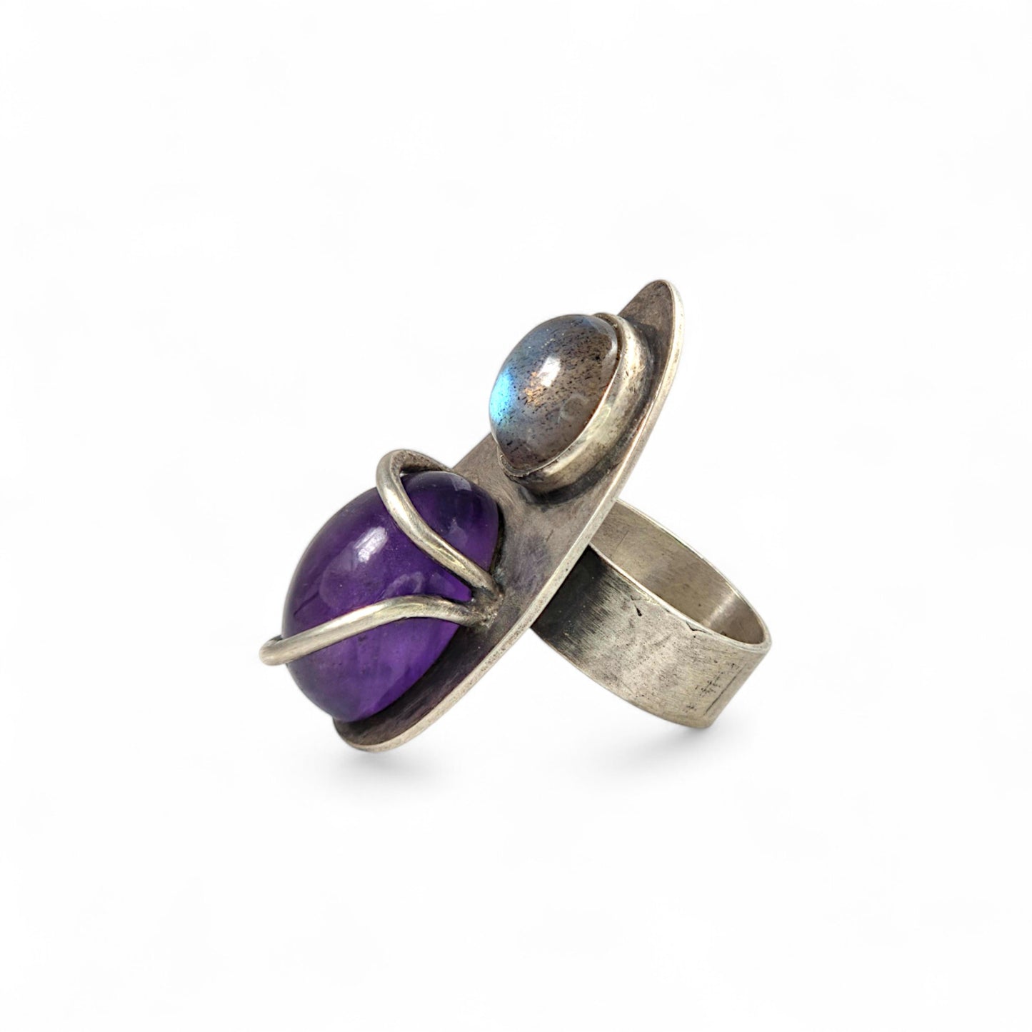 Silver ring with a purple gemstone on a white background
