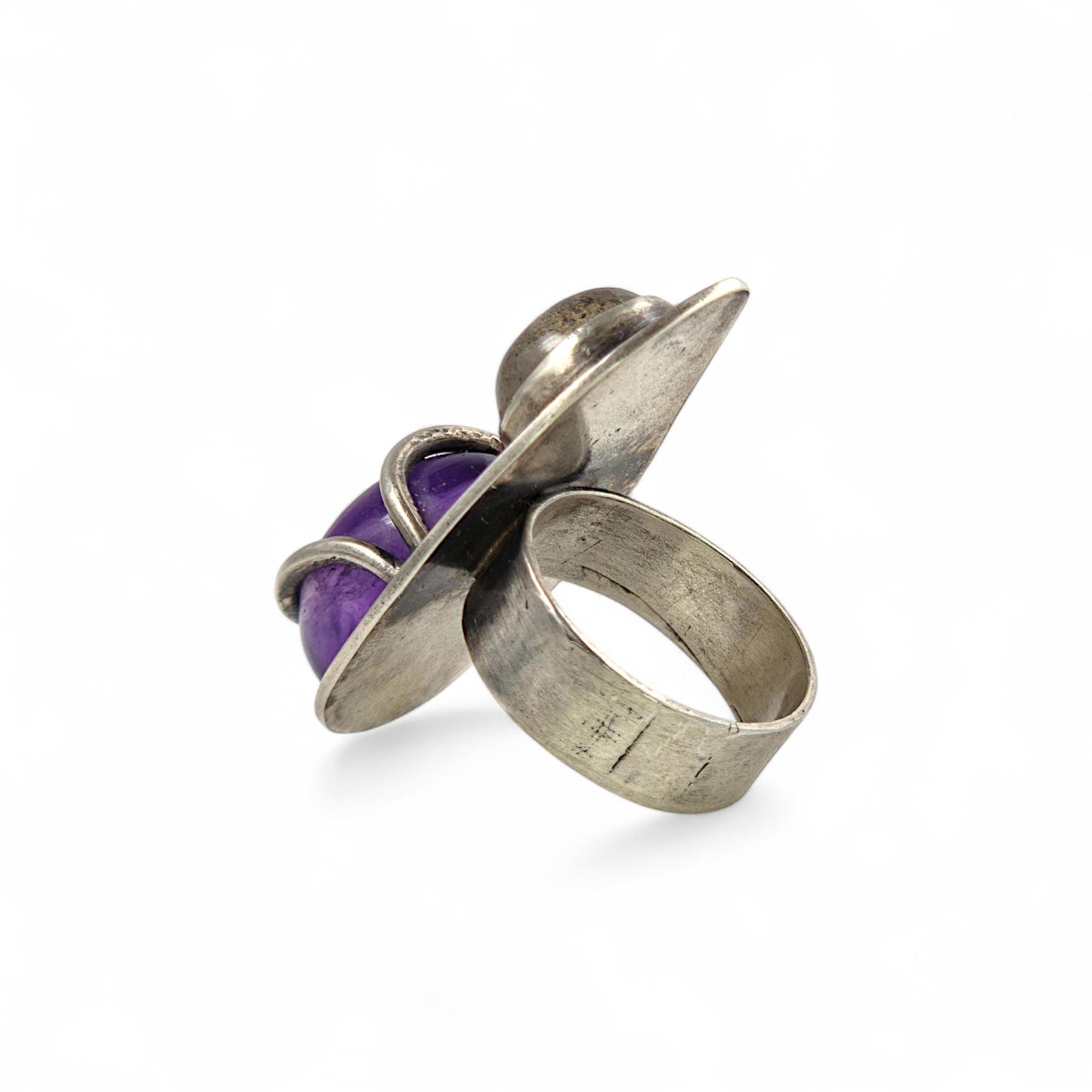 Silver ring with a purple gemstone on a white background