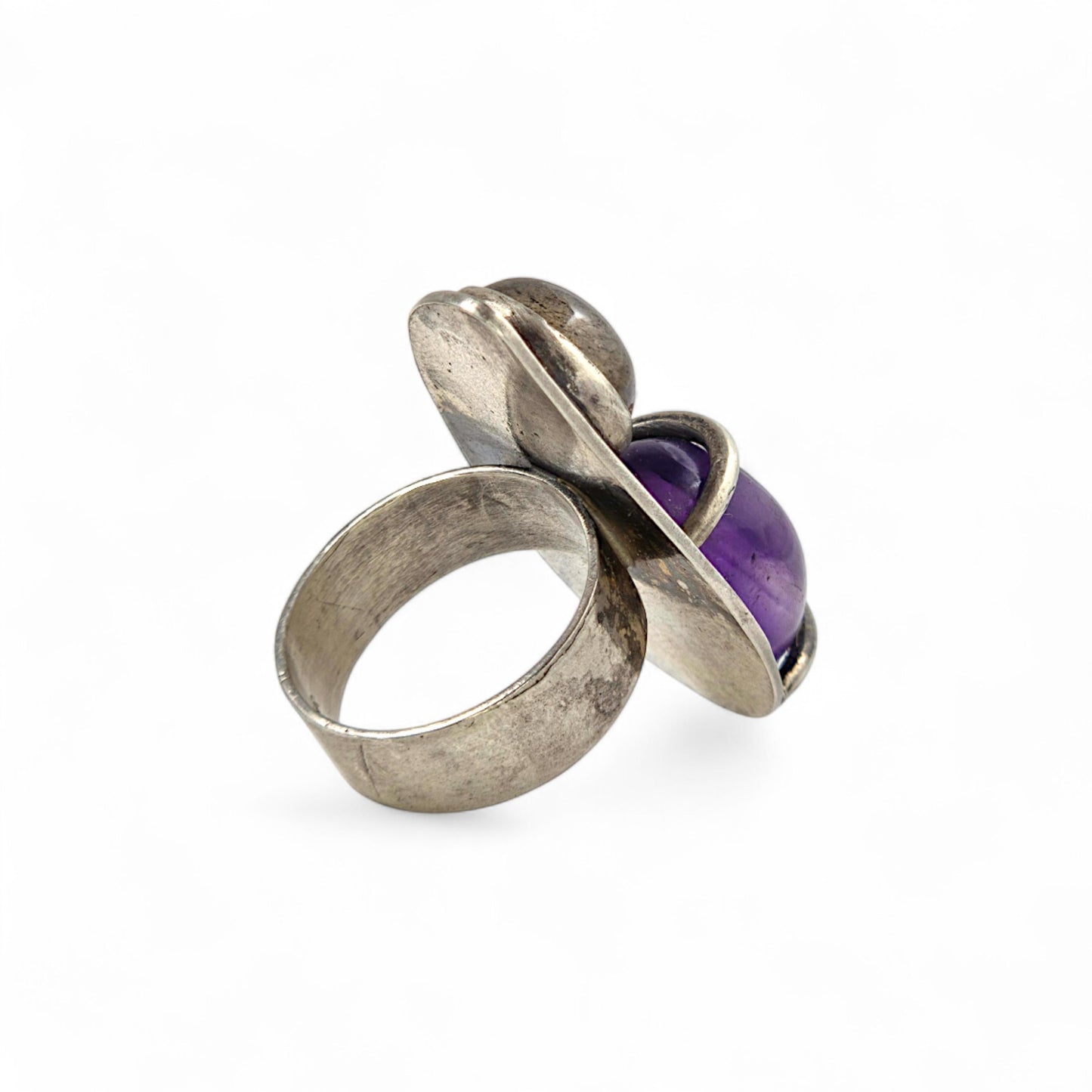 Silver ring with a purple gemstone on a white background