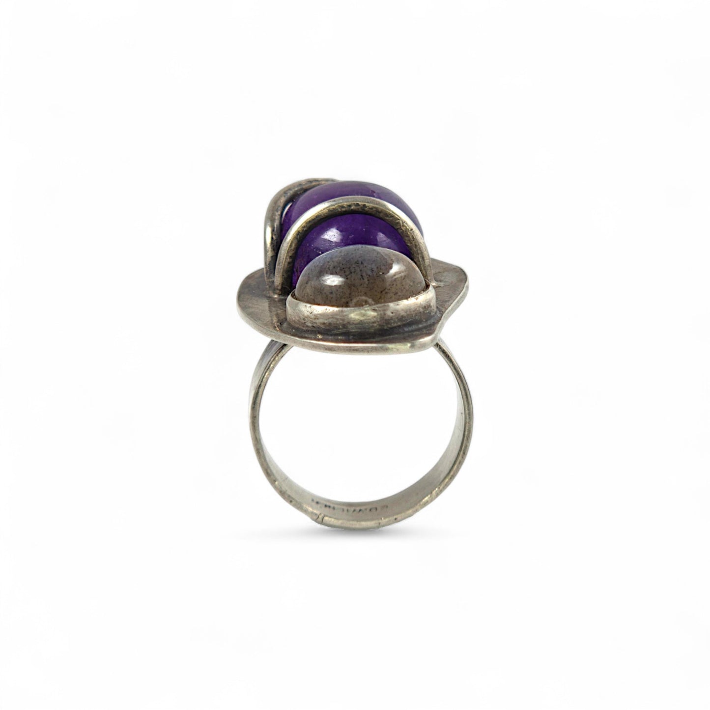 Silver ring with a purple gemstone on a white background