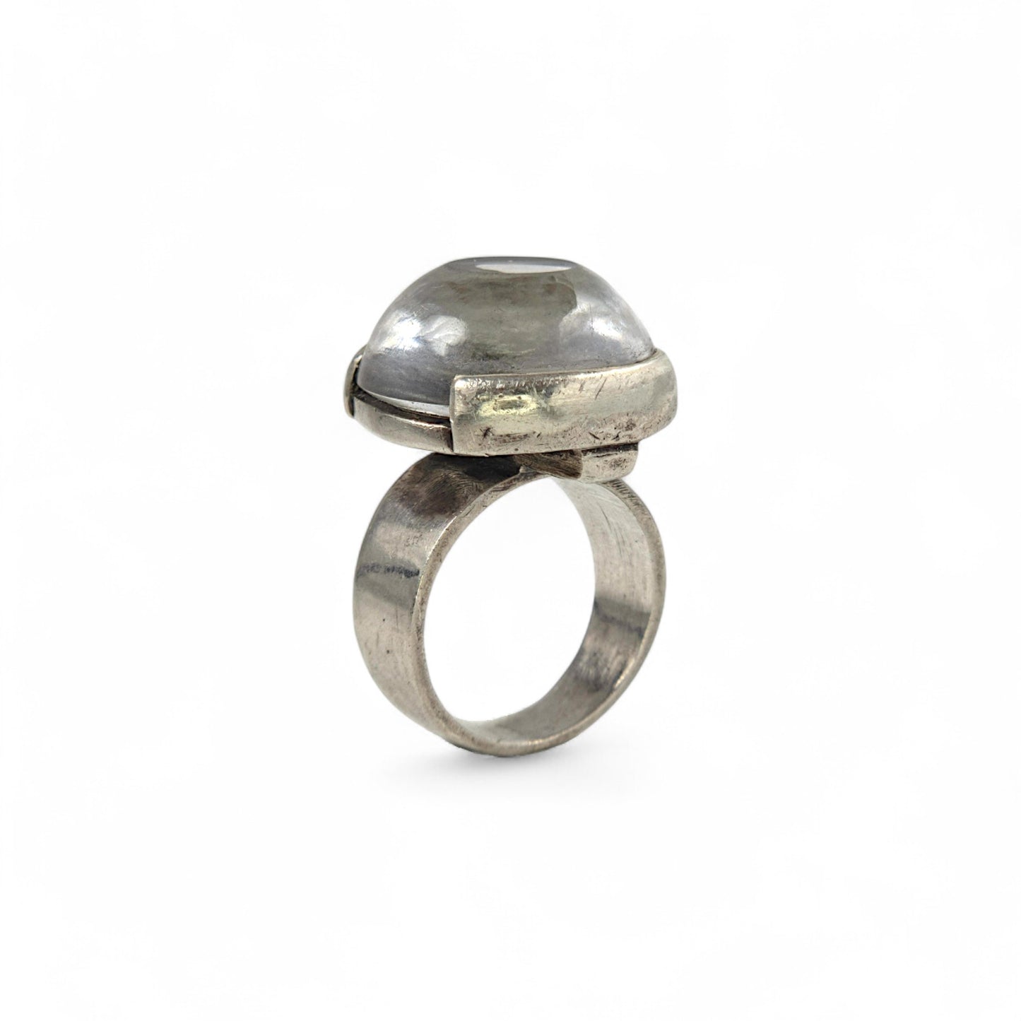 Silver ring with a large, clear gemstone on a white background