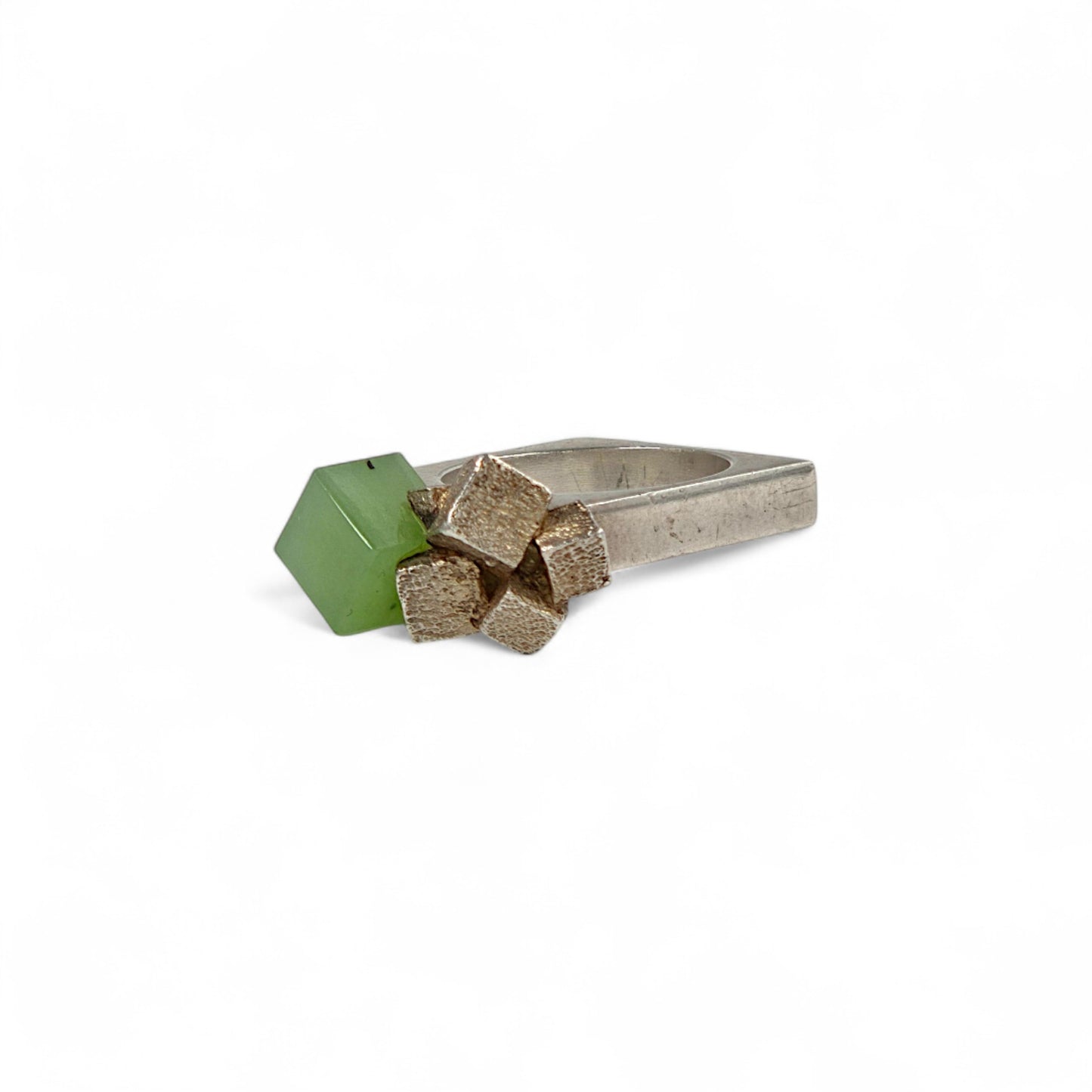 Ring with geometric green and cube design on a white background