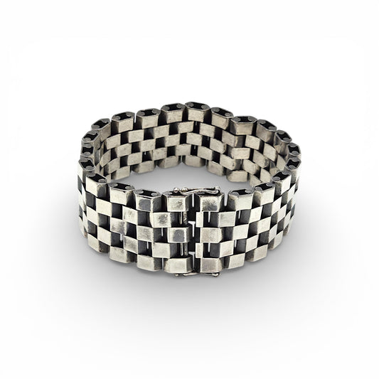 Silver bracelet with a checkered pattern on a white background
