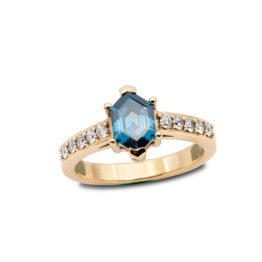 Gold ring with a blue gemstone and diamond accents on a white background