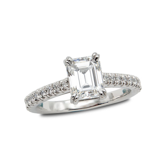 Diamond ring with emerald-cut center stone on a white background