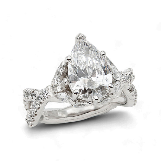 Diamond ring with a pear-shaped center stone on a white background