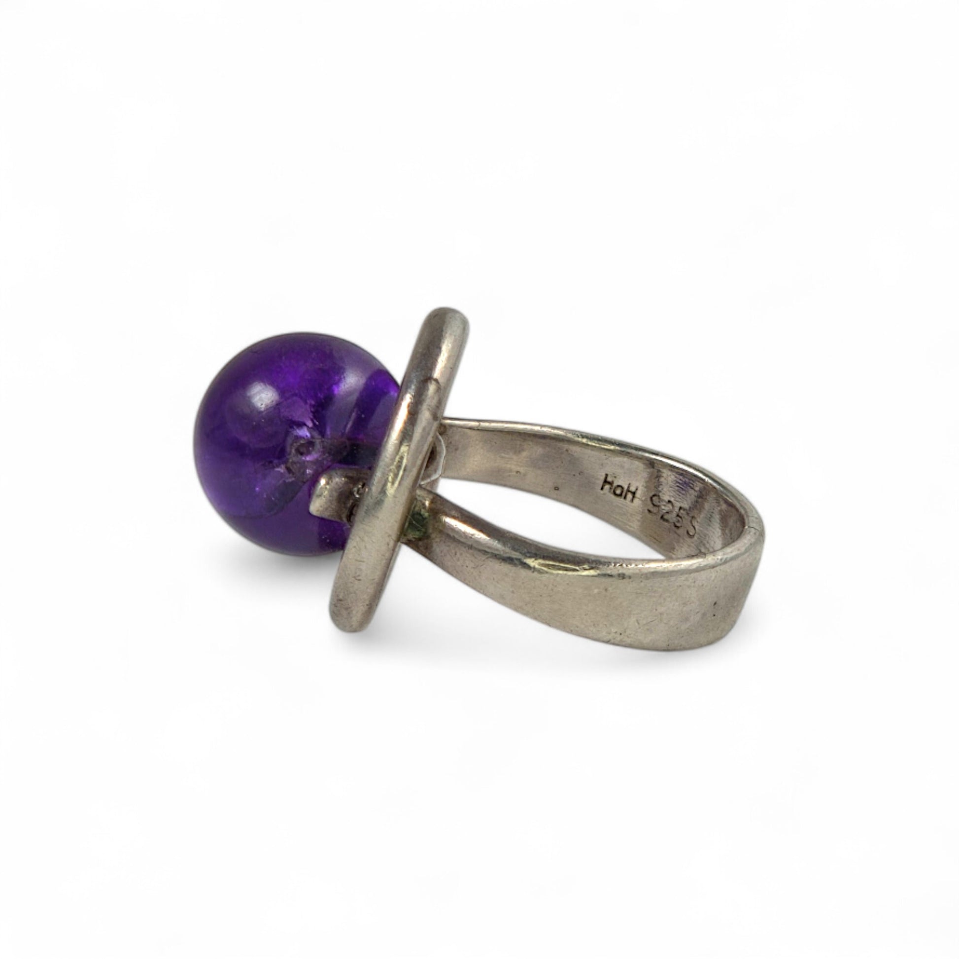 Silver ring with a purple gemstone on a white background