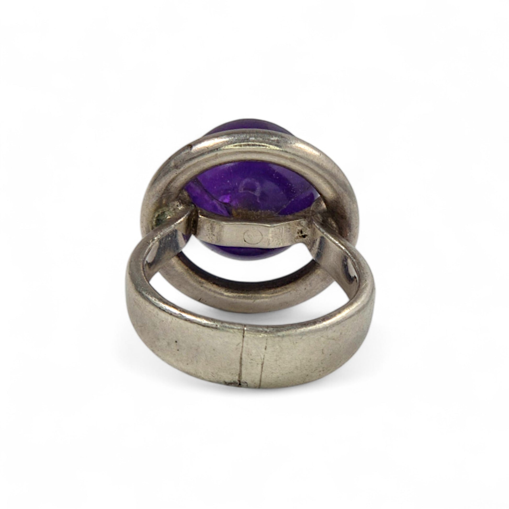 Silver ring with a purple gemstone on a white background
