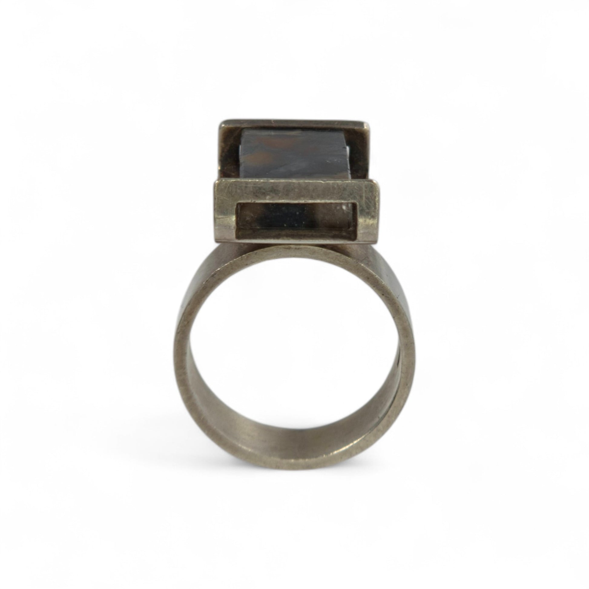 Silver ring with a dark stone on a white background