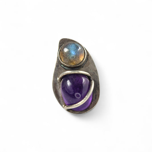 Jewelry ring with purple gemstone and labradorite on a white background