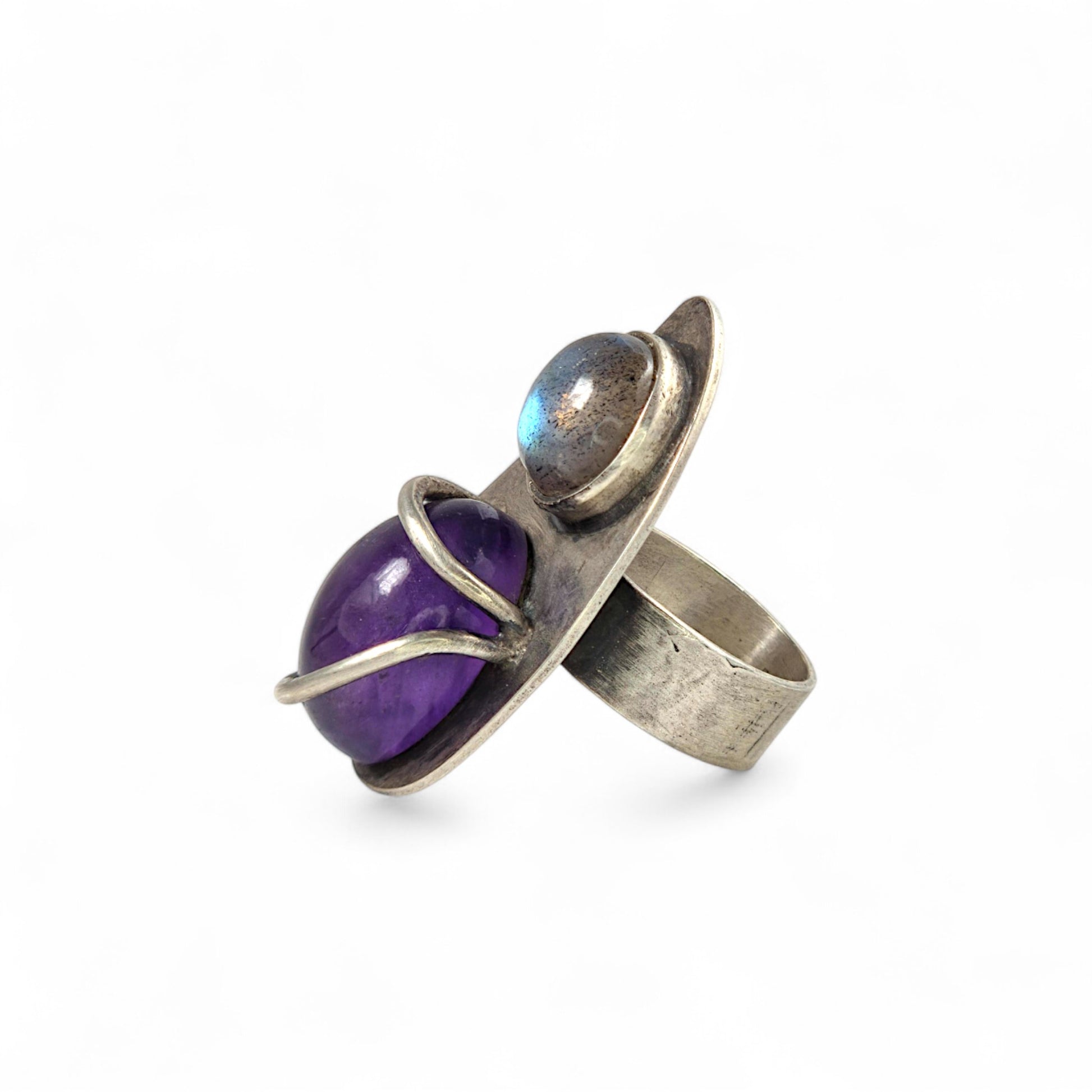 Silver ring with a purple gemstone on a white background