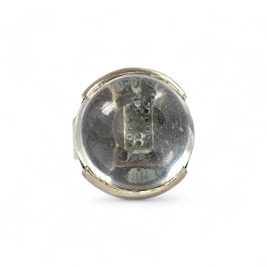 Round silver object with a clear center on a white background