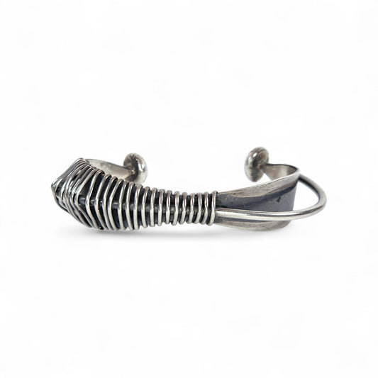 Silver wire-crafted bracelet on a white background