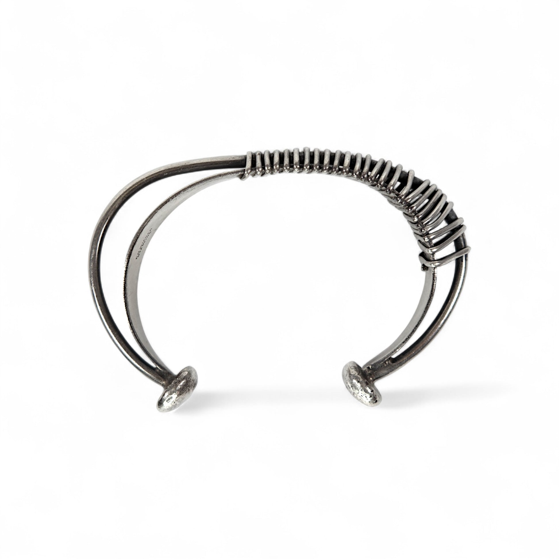 Silver bracelet with a textured band on a white background