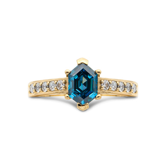 Gold ring with a blue gemstone and smaller diamonds on a white background