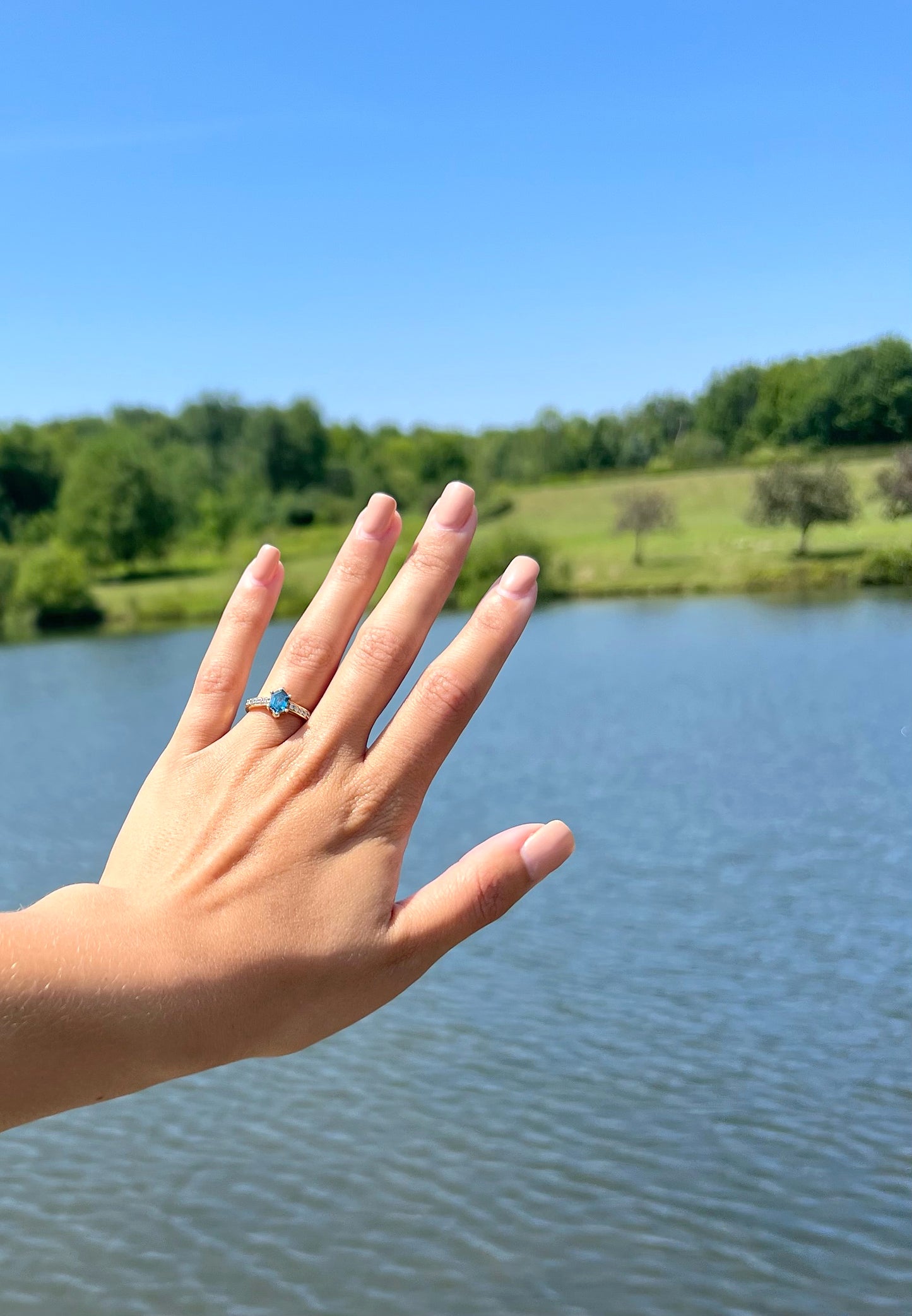 Hand with a ring on a lake background