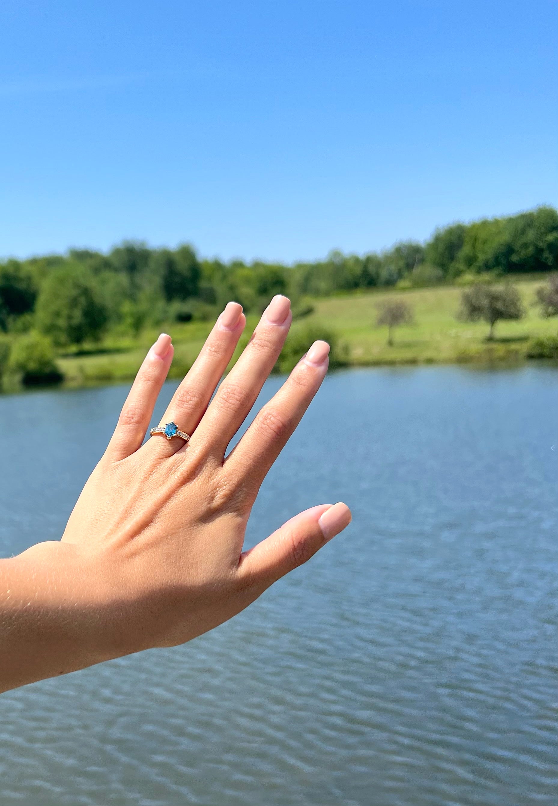 Hand with a ring on a lake background