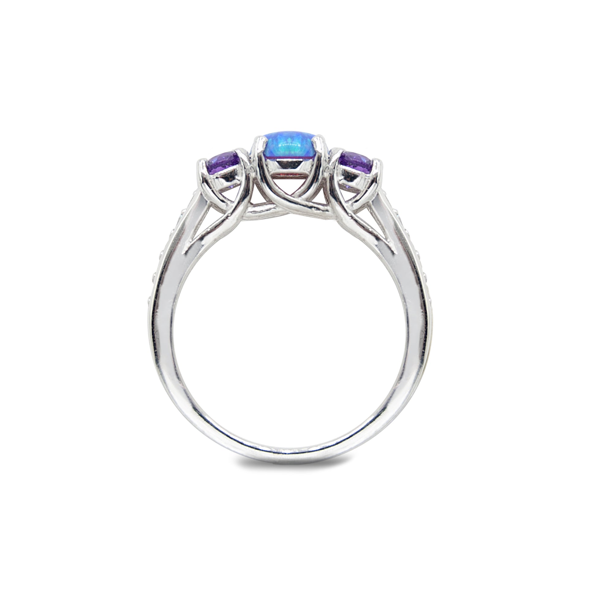 Platinum ring with a central blue gemstone flanked by two purple gemstones on a white background