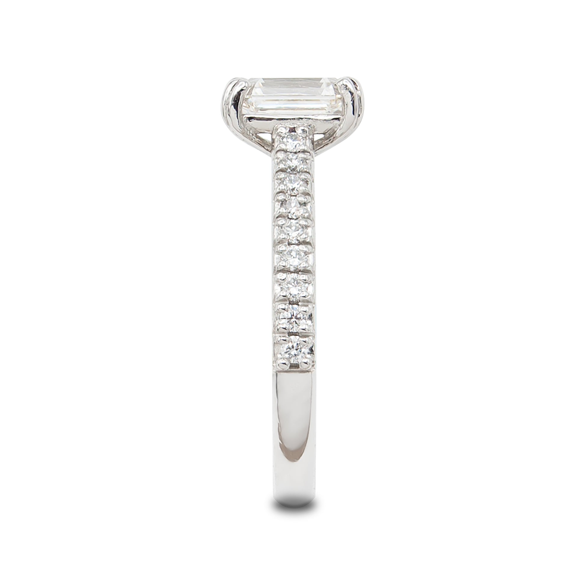 Diamond ring with a emerald-cut center stone on a white background