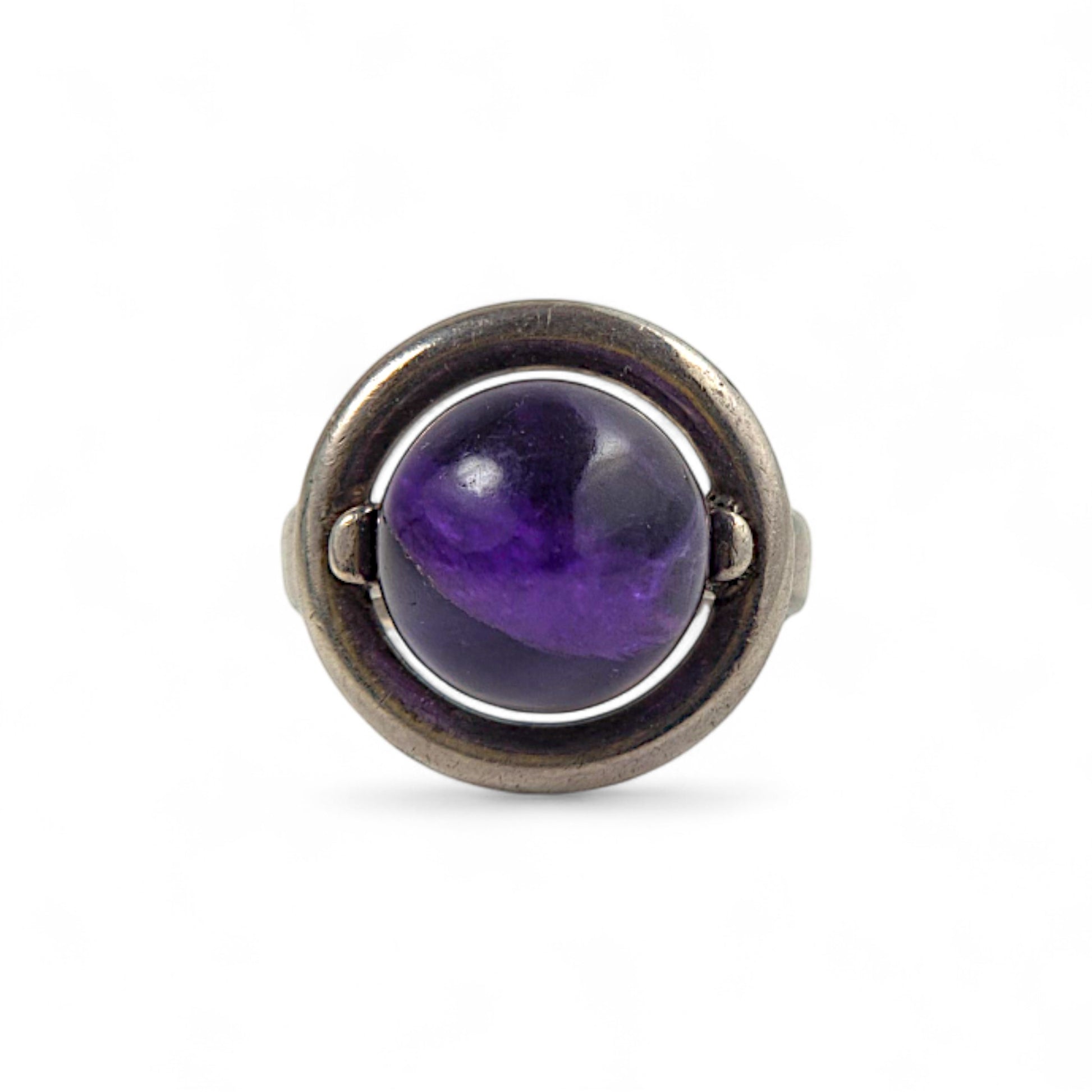 Ring with a purple gemstone and silver band on a white background